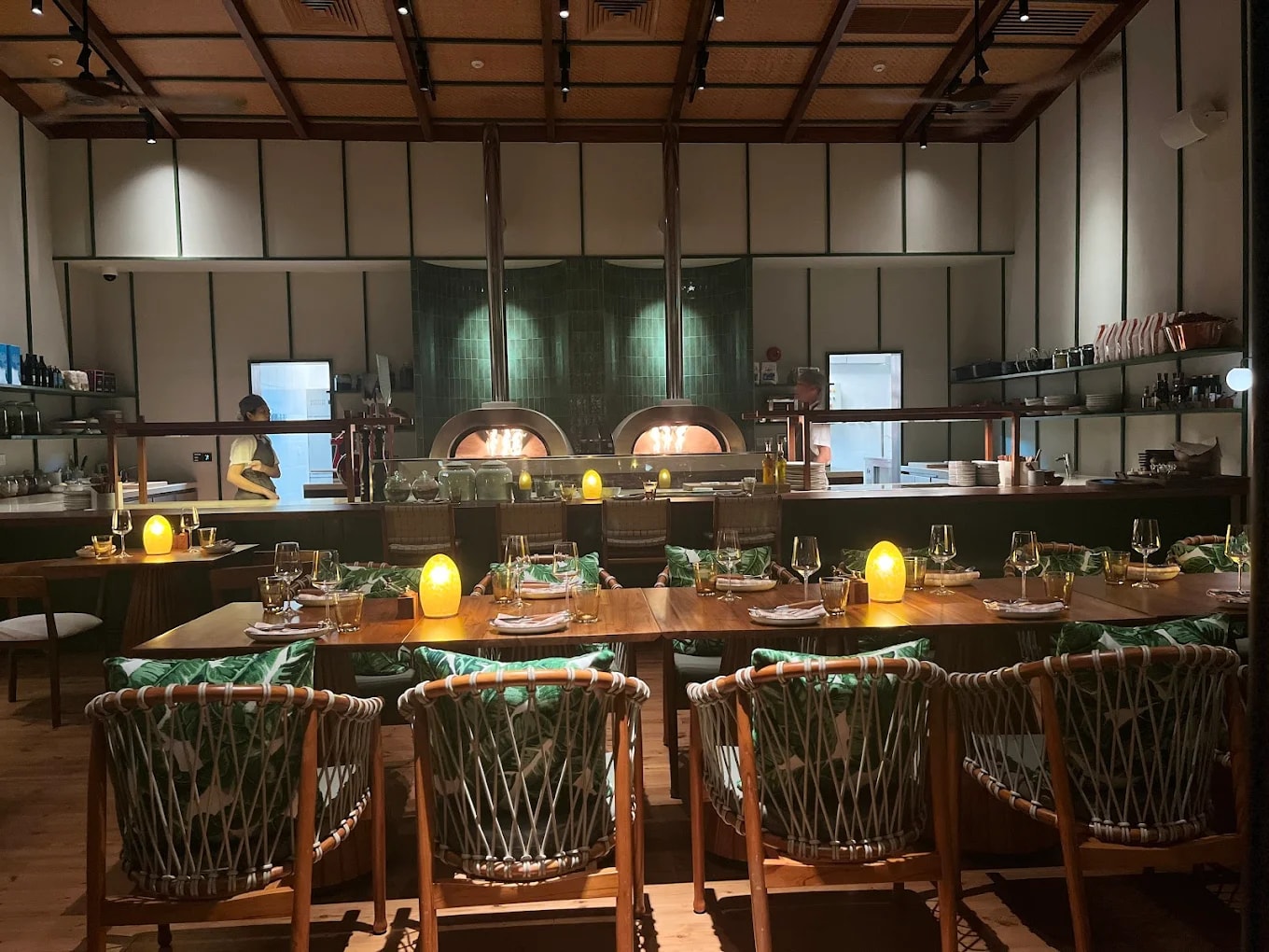 The indoor dining area features sleek wooden interiors and soft ambient lighting that create a refined yet welcoming atmosphere